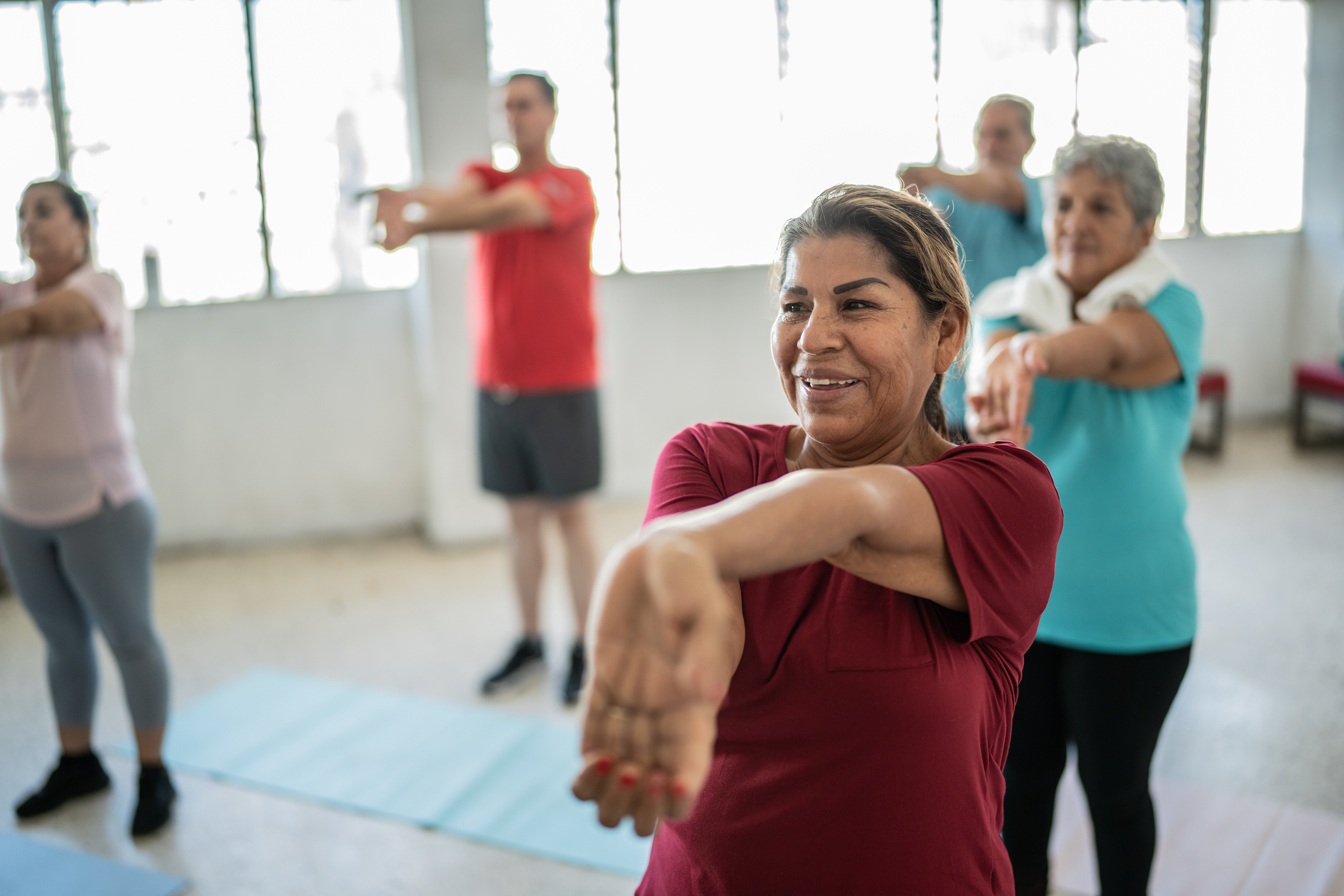 Senior woman stretching with classmates